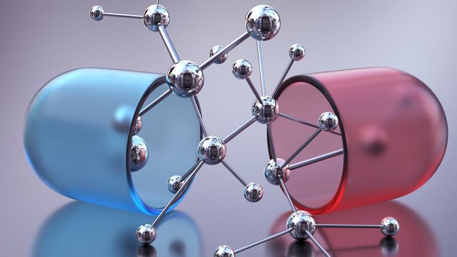 A drug capsule split open to reveal a molecule. 