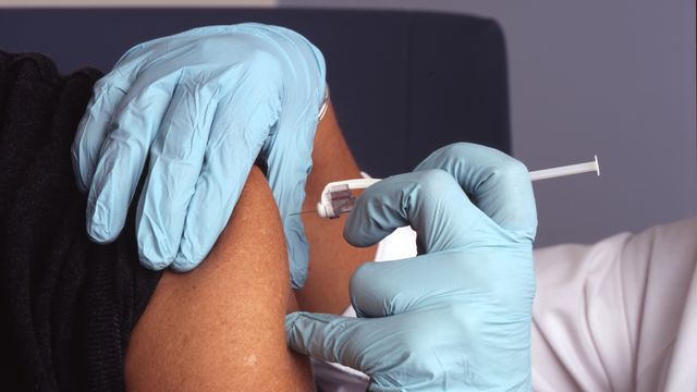 A person receiving a vaccine shot in their arm. 