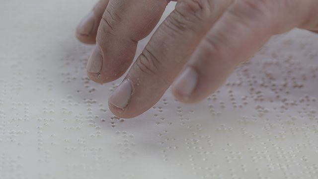 Fingers over braille. 